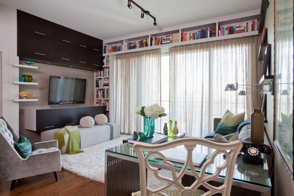 Esempio di un piccolo soggiorno contemporaneo chiuso con pareti beige, pavimento in legno massello medio e TV a parete