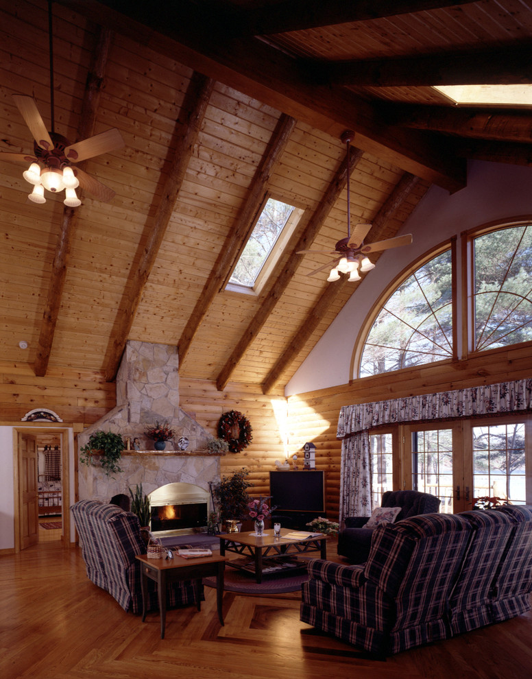 Example of a large loft-style medium tone wood floor game room design in Boston with white walls, a standard fireplace, a stone fireplace and a corner tv