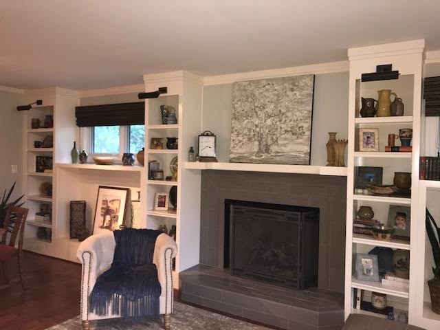 На фото: открытая гостиная комната среднего размера в стиле неоклассика (современная классика) с серыми стенами, темным паркетным полом, стандартным камином, фасадом камина из бетона, отдельно стоящим телевизором и коричневым полом с