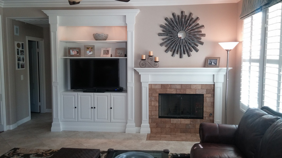 Imagen de sala de estar abierta tradicional de tamaño medio con paredes beige, suelo de travertino, todas las chimeneas, marco de chimenea de ladrillo, pared multimedia y suelo beige