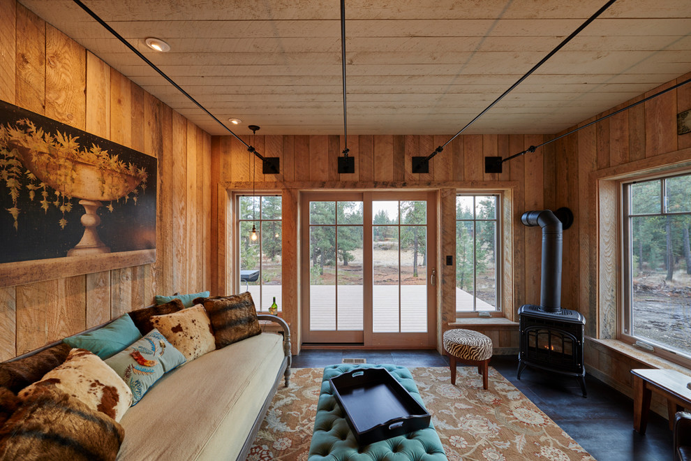 Cette image montre une salle de séjour chalet de taille moyenne et fermée avec un mur beige, parquet foncé, un poêle à bois, un manteau de cheminée en métal, aucun téléviseur et un sol noir.