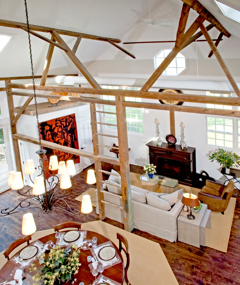 Cette photo montre une grande salle de séjour nature ouverte avec un mur blanc, parquet foncé, un manteau de cheminée en bois et aucun téléviseur.