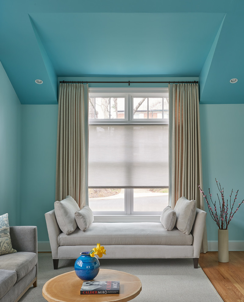 На фото: гостиная комната в стиле неоклассика (современная классика) с синими стенами, паркетным полом среднего тона, двусторонним камином и фасадом камина из камня с