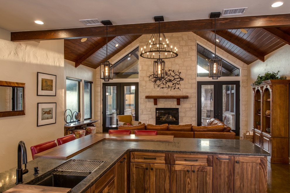 Inspiration for a mid-sized craftsman open concept concrete floor and brown floor family room remodel in Austin with a standard fireplace and a stone fireplace
