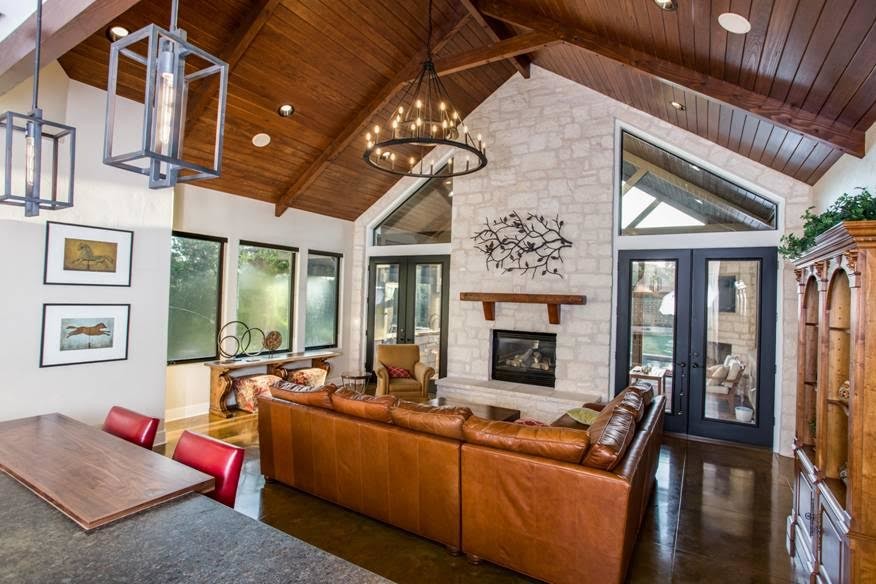 Mid-sized arts and crafts open concept concrete floor and brown floor family room photo in Austin with a standard fireplace and a stone fireplace