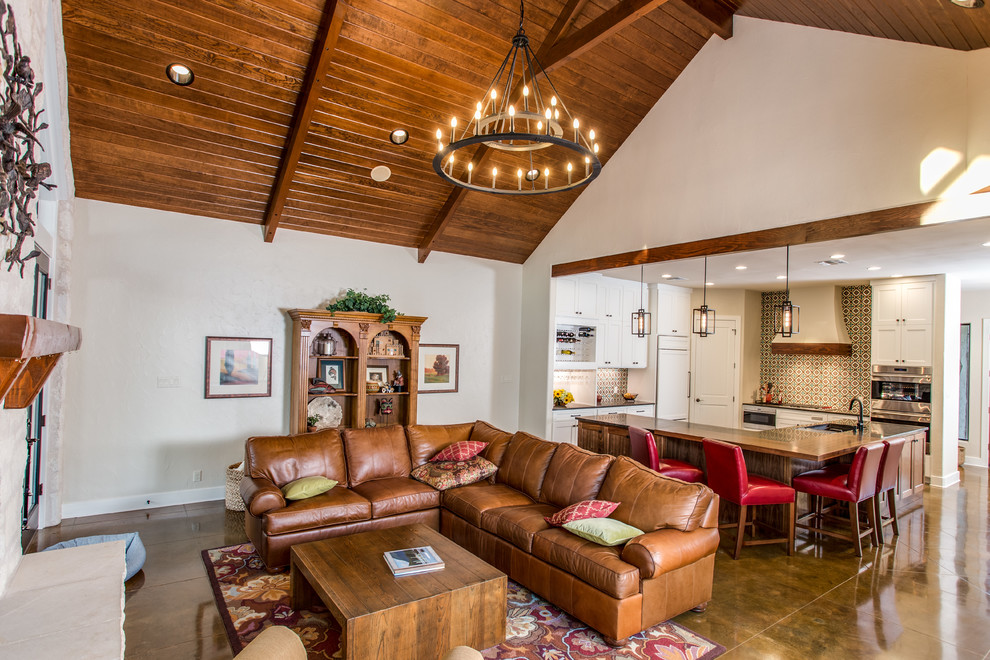 This is an example of a medium sized traditional open plan games room in Austin with concrete flooring, a standard fireplace, a stone fireplace surround and brown floors.