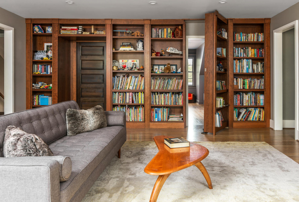 Réalisation d'une salle de séjour design avec une bibliothèque ou un coin lecture, un mur gris, un sol en bois brun et un sol marron.