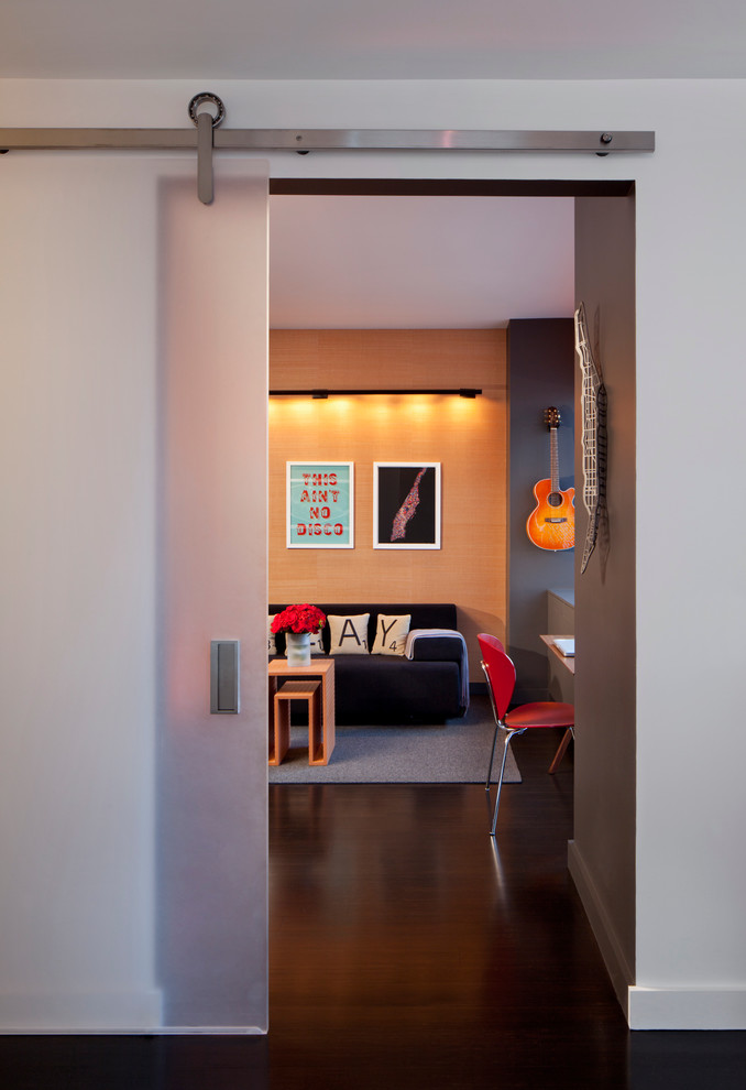 Imagen de sala de estar cerrada actual de tamaño medio sin chimenea y televisor con suelo de madera oscura y paredes multicolor