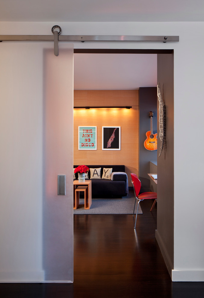 Photo of a medium sized contemporary enclosed games room in New York with dark hardwood flooring, multi-coloured walls, no fireplace and no tv.