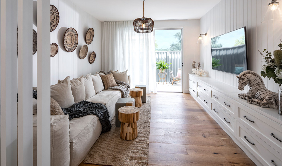Großes, Abgetrenntes Maritimes Wohnzimmer mit weißer Wandfarbe, braunem Holzboden, TV-Wand, braunem Boden und Holzdielenwänden in Sonstige