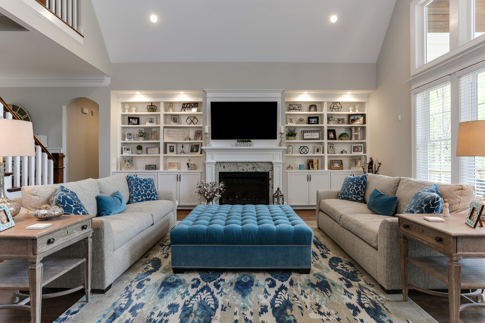 Large classic open plan games room in Raleigh with medium hardwood flooring, a standard fireplace, a stone fireplace surround, a wall mounted tv, brown floors and grey walls.