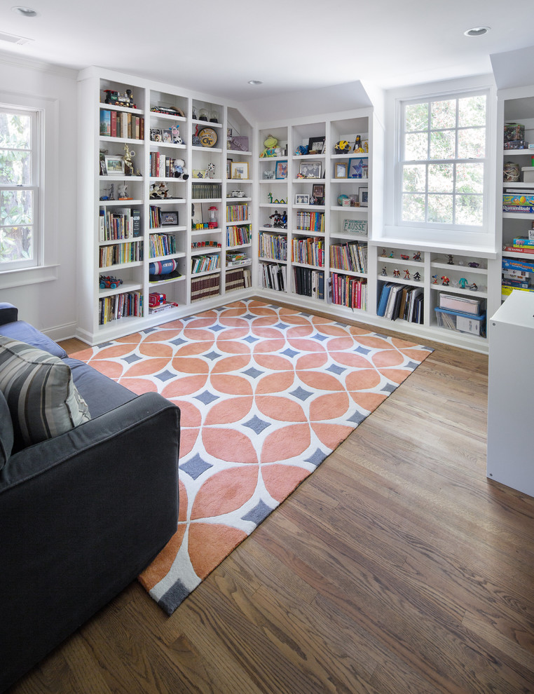 Imagen de sala de estar con biblioteca cerrada clásica renovada de tamaño medio sin chimenea y televisor con paredes grises, suelo de madera en tonos medios y suelo marrón