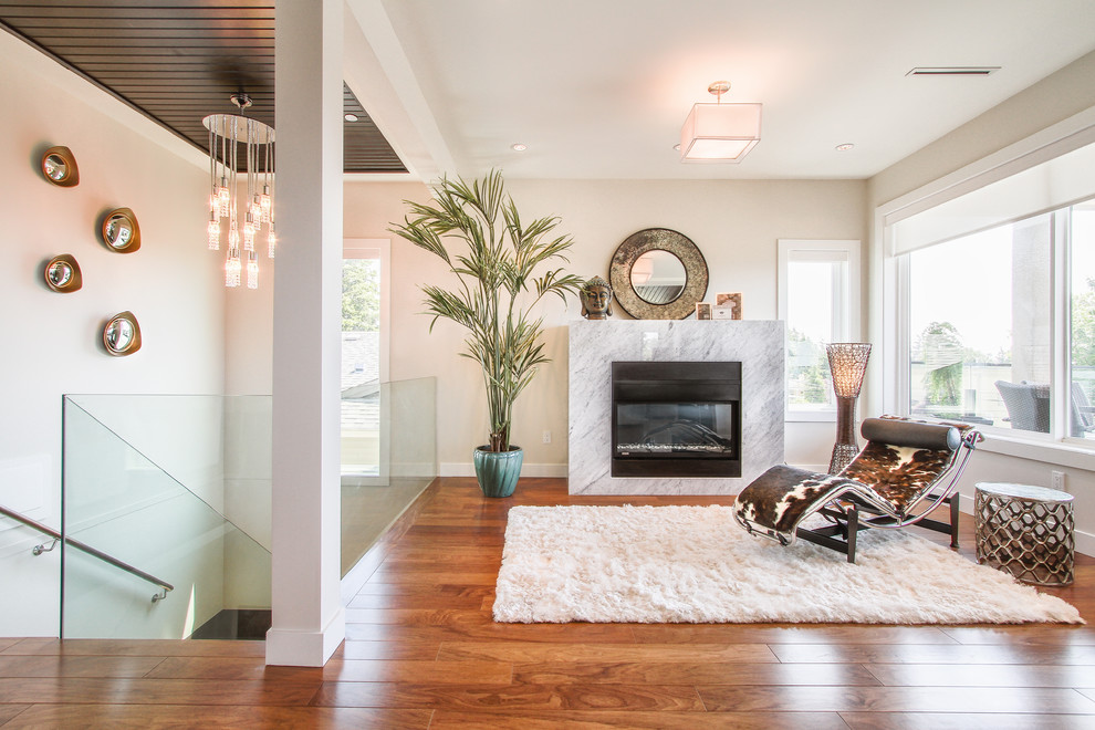 Imagen de sala de estar contemporánea pequeña con paredes beige, suelo de madera en tonos medios, todas las chimeneas y marco de chimenea de piedra
