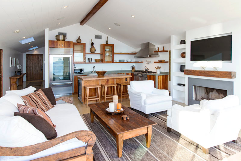 Diseño de sala de estar abierta contemporánea de tamaño medio con paredes blancas, chimenea lineal, marco de chimenea de metal y televisor colgado en la pared