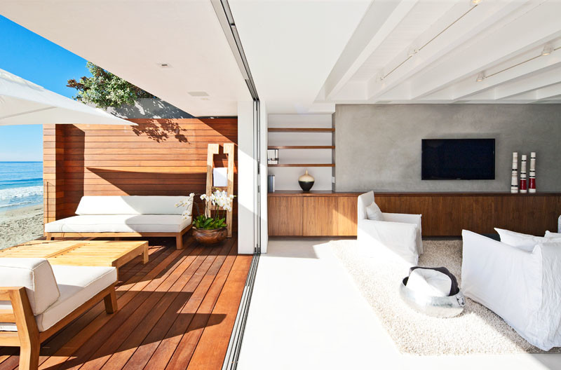 Пример оригинального дизайна: открытая гостиная комната среднего размера в стиле модернизм с белыми стенами, бетонным полом, телевизором на стене и серым полом без камина