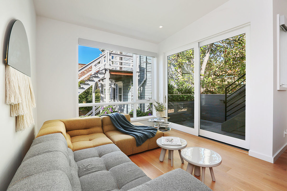 Fernseherloses Modernes Wohnzimmer ohne Kamin mit weißer Wandfarbe und braunem Holzboden in San Francisco