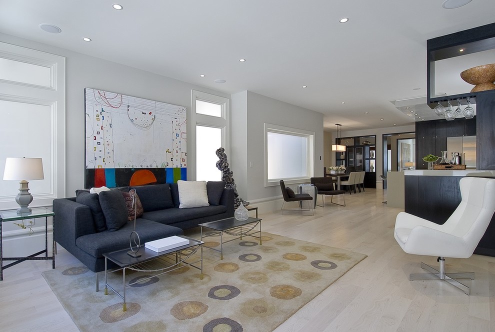 Ejemplo de salón abierto actual con paredes grises, suelo de madera clara, suelo beige y alfombra