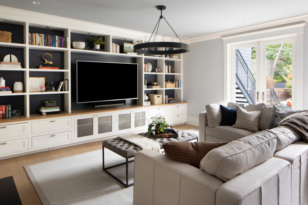 Пример оригинального дизайна: гостиная комната в стиле неоклассика (современная классика) с серыми стенами, паркетным полом среднего тона, мультимедийным центром и коричневым полом