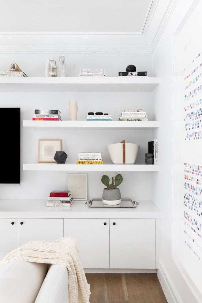 Imagen de sala de juegos en casa abierta minimalista grande con paredes blancas, suelo de madera clara, televisor colgado en la pared y suelo beige