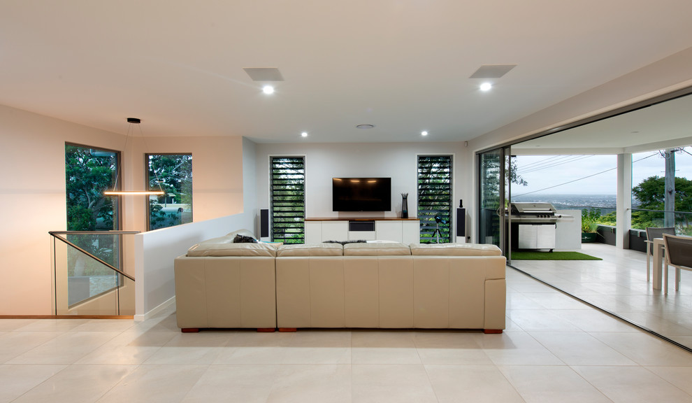 Großes, Offenes Modernes Wohnzimmer ohne Kamin mit weißer Wandfarbe, Keramikboden, freistehendem TV und beigem Boden in Sunshine Coast