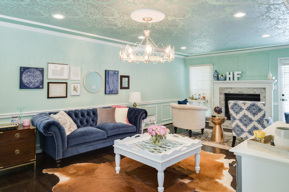 Imagen de sala de estar abierta ecléctica grande con paredes azules, suelo de madera oscura, todas las chimeneas y marco de chimenea de piedra