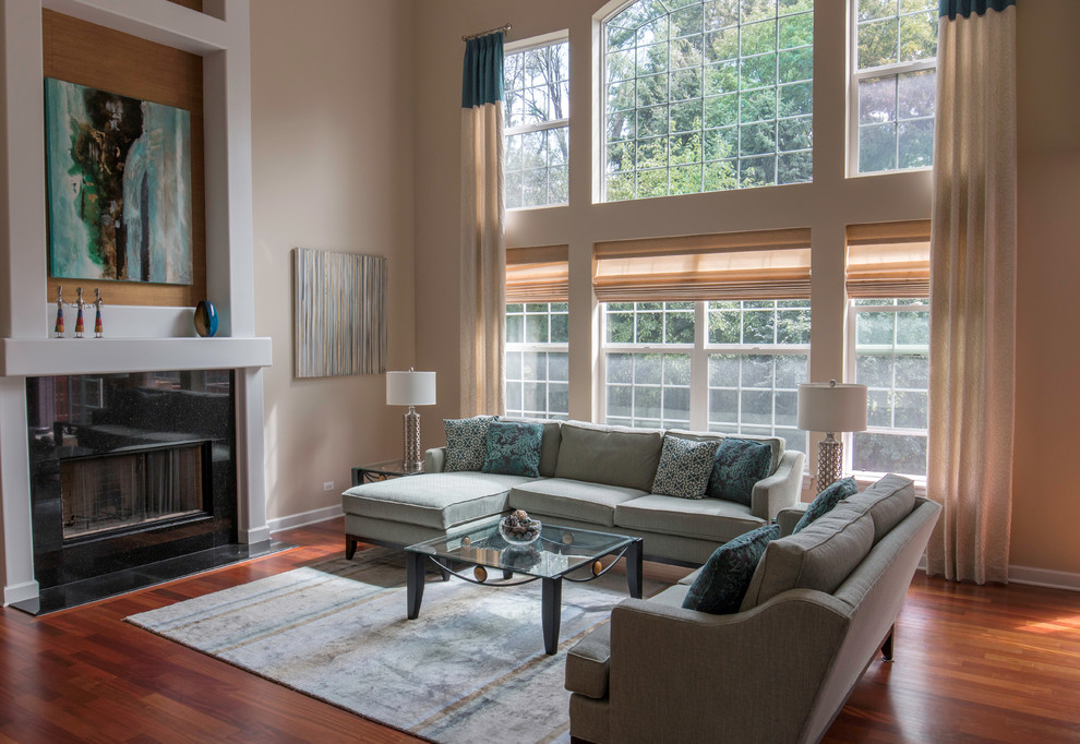 Ejemplo de sala de estar abierta contemporánea de tamaño medio con paredes beige, suelo de madera en tonos medios, todas las chimeneas, marco de chimenea de yeso y televisor independiente