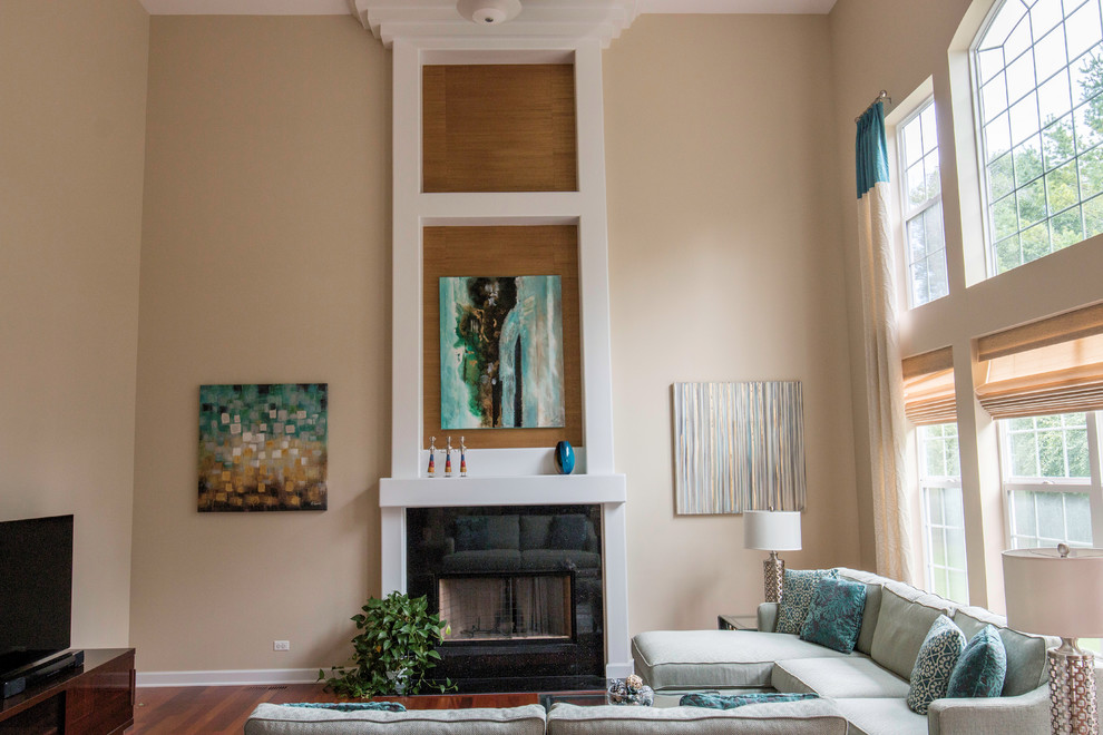 Foto de sala de estar abierta contemporánea de tamaño medio con paredes beige, suelo de madera en tonos medios, todas las chimeneas, marco de chimenea de yeso y televisor independiente