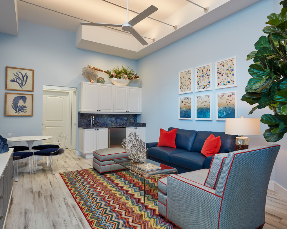 На фото: изолированная гостиная комната в морском стиле с домашним баром, синими стенами, бежевым полом и ковром на полу без камина