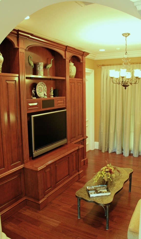 Diseño de sala de estar abierta clásica de tamaño medio con paredes beige, suelo de madera en tonos medios, pared multimedia y suelo marrón