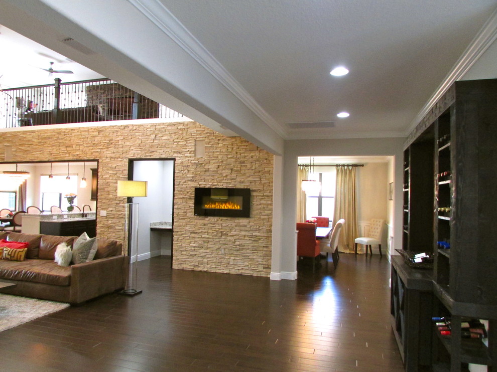 Diseño de sala de estar actual de tamaño medio con suelo de madera oscura, chimenea lineal y marco de chimenea de piedra