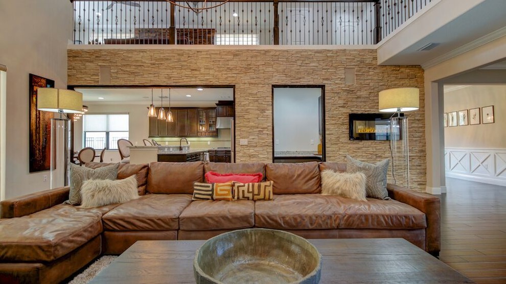 Ejemplo de sala de estar abierta contemporánea de tamaño medio sin televisor con suelo de madera oscura, chimenea lineal y marco de chimenea de piedra