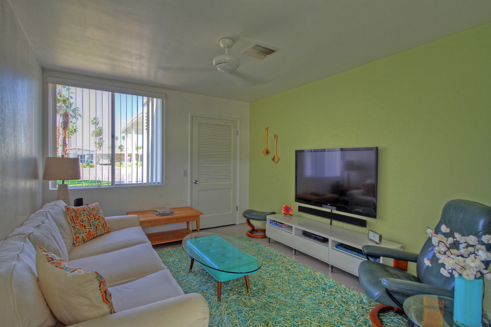 Cette photo montre une salle de séjour moderne de taille moyenne et fermée avec un téléviseur fixé au mur, un mur vert, un sol en carrelage de céramique, aucune cheminée et un sol gris.
