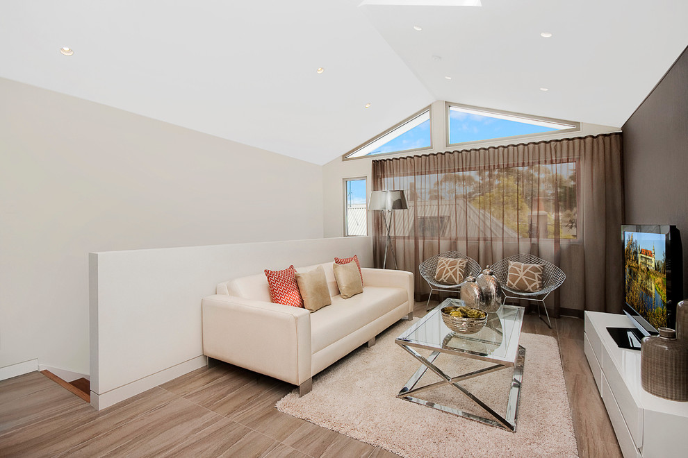 Imagen de sala de estar tipo loft actual de tamaño medio con paredes marrones, televisor independiente y suelo de madera clara