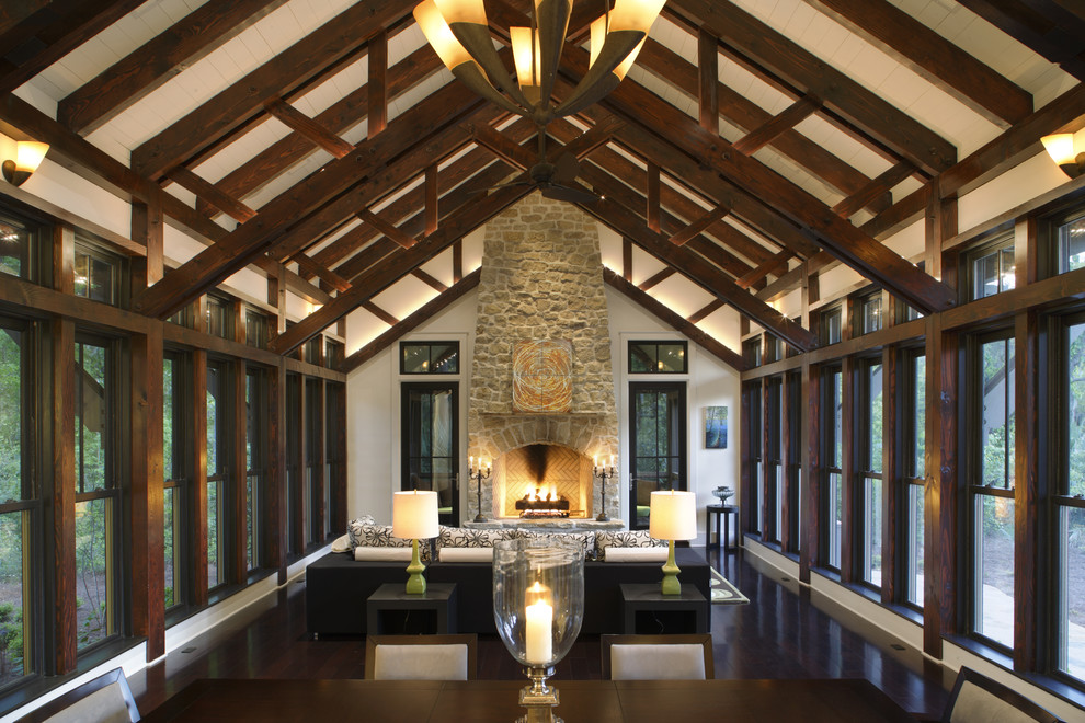 Diseño de sala de estar abierta tradicional renovada con paredes beige, suelo de madera oscura, todas las chimeneas y marco de chimenea de piedra