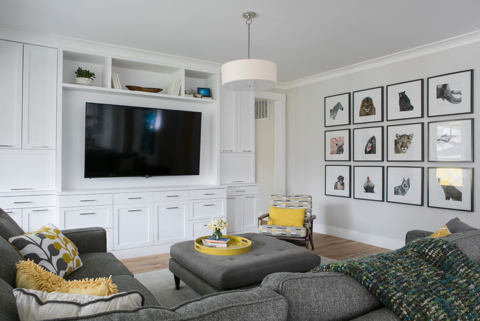Источник вдохновения для домашнего уюта: открытая гостиная комната среднего размера в стиле неоклассика (современная классика) с серыми стенами, светлым паркетным полом и телевизором на стене без камина