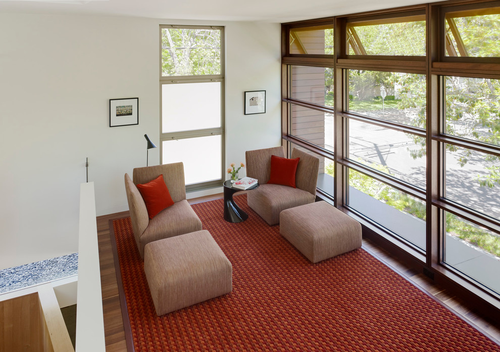 Exemple d'une salle de séjour mansardée ou avec mezzanine moderne de taille moyenne avec un mur blanc et un sol en bois brun.