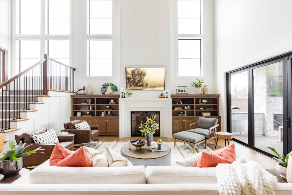 Offenes Klassisches Wohnzimmer mit weißer Wandfarbe, braunem Holzboden, Kamin und gewölbter Decke in Portland