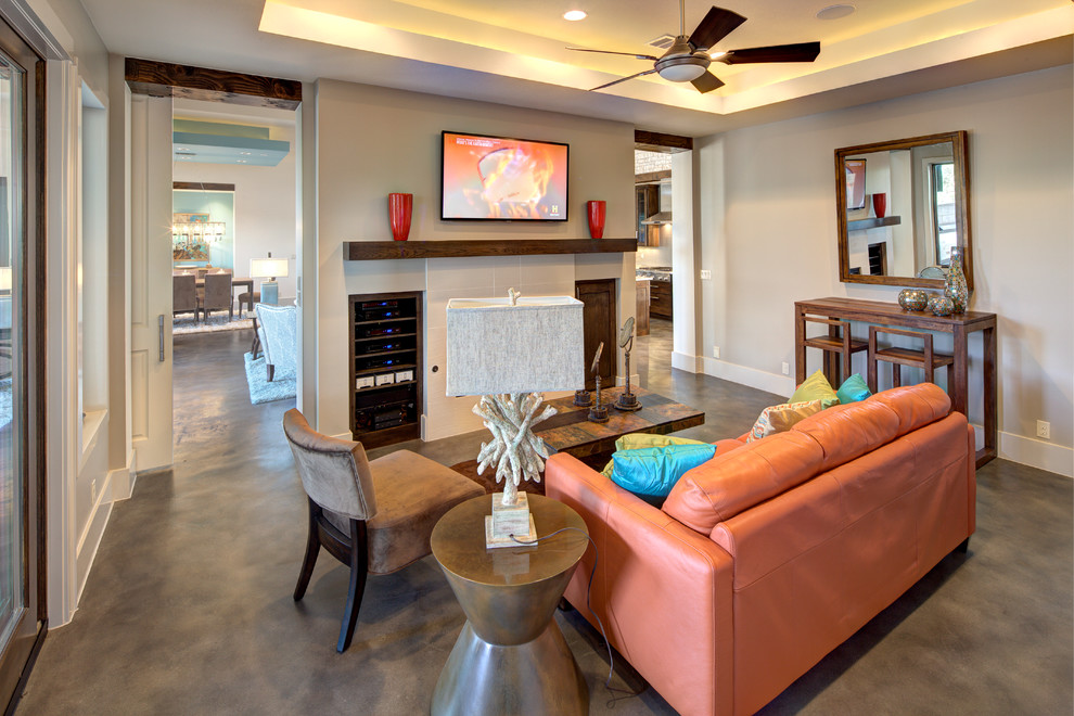 Medium sized contemporary open plan games room in Austin with beige walls, concrete flooring, a wall mounted tv and grey floors.