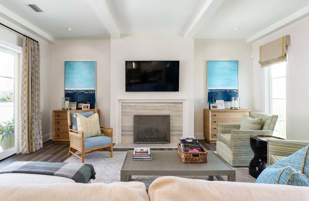 Maritimes Wohnzimmer mit beiger Wandfarbe, dunklem Holzboden, Kamin, Kaminumrandung aus Stein und TV-Wand in Jacksonville
