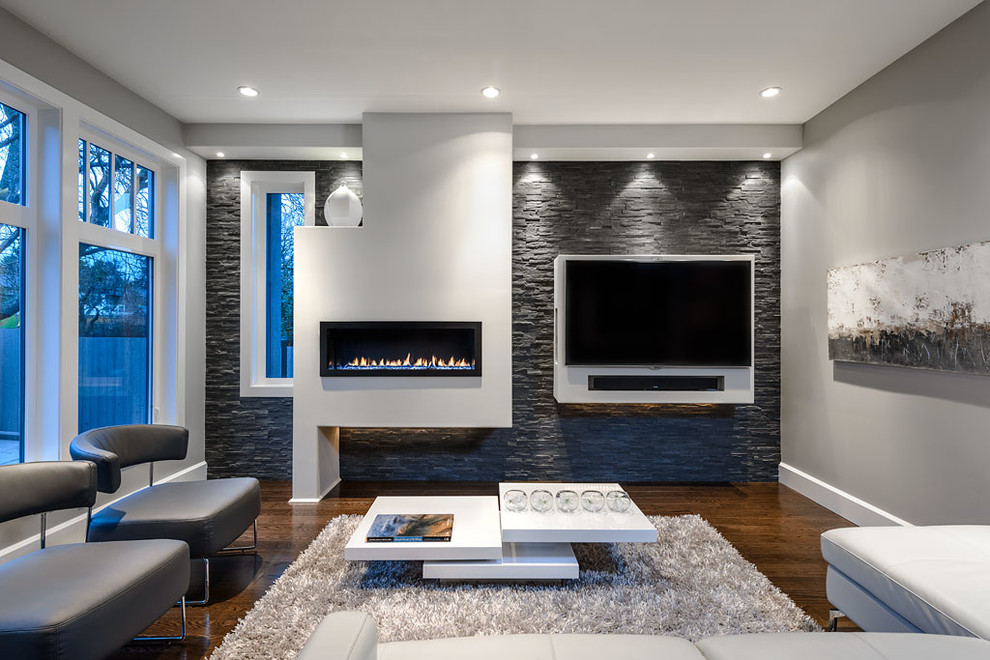 Cette image montre une salle de séjour design avec un mur gris, parquet foncé, une cheminée ribbon et un téléviseur fixé au mur.