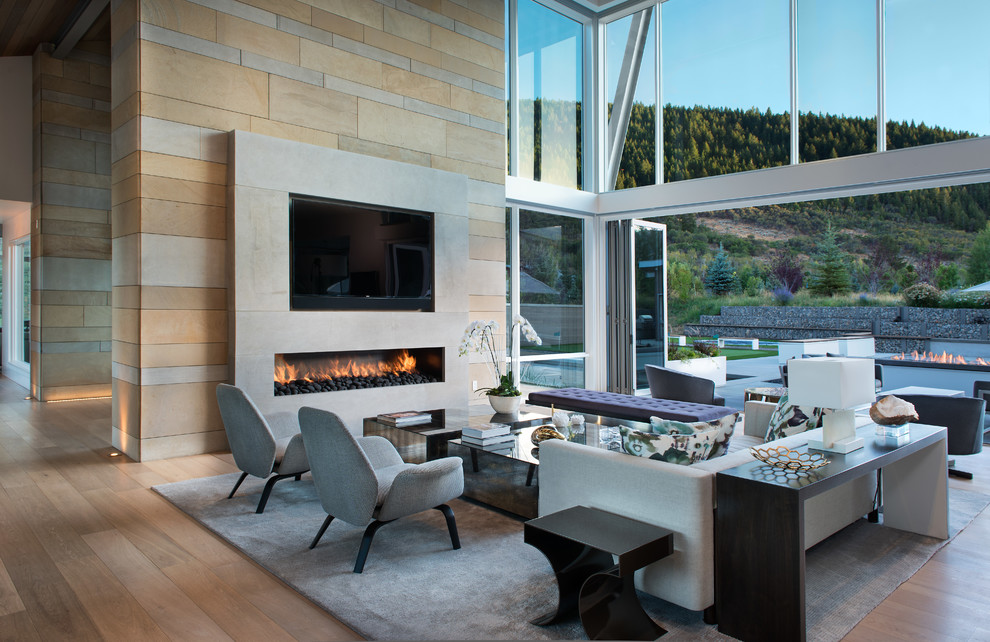 Foto di un soggiorno design aperto con parquet chiaro, camino lineare Ribbon, TV a parete e pavimento beige