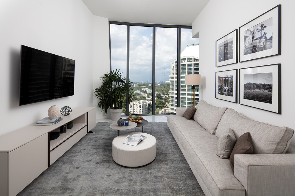 マイアミにあるコンテンポラリースタイルのおしゃれな独立型ファミリールーム (白い壁、壁掛け型テレビ、グレーの床) の写真
