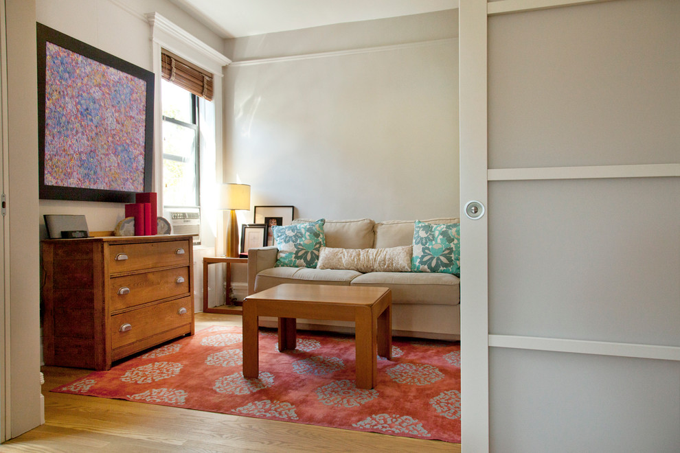 Foto di un soggiorno design di medie dimensioni e chiuso con pareti beige e pavimento in legno massello medio
