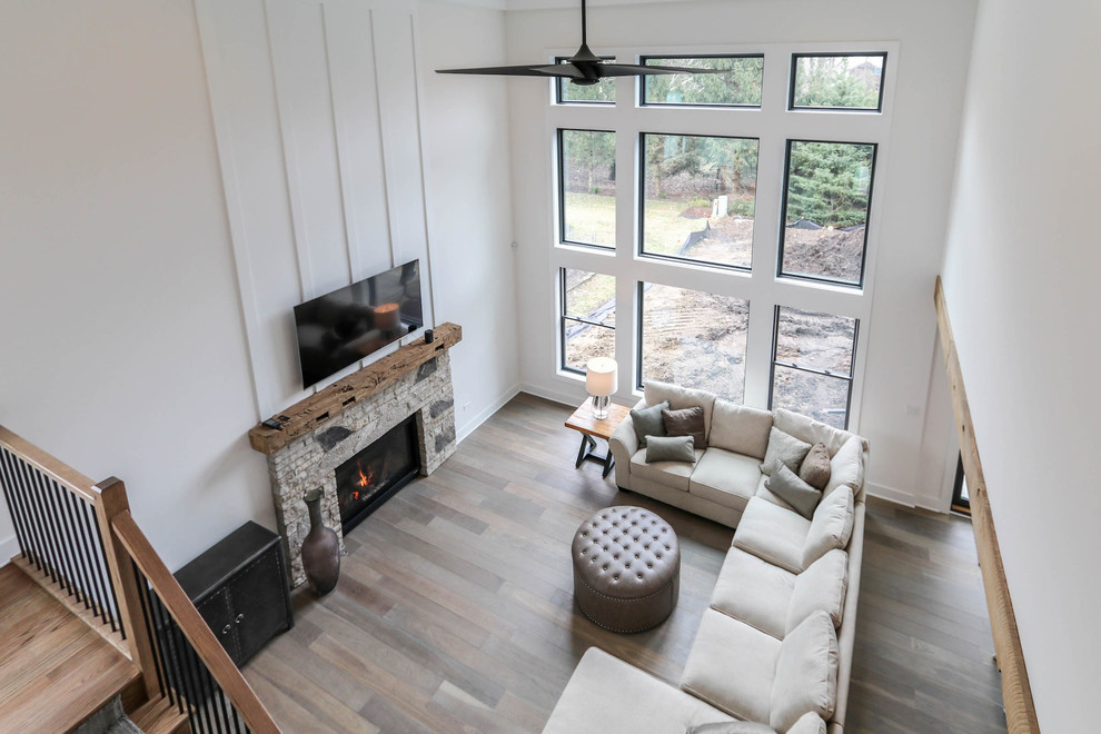 Ejemplo de sala de estar tipo loft de estilo de casa de campo de tamaño medio con paredes blancas, suelo de madera clara y suelo marrón