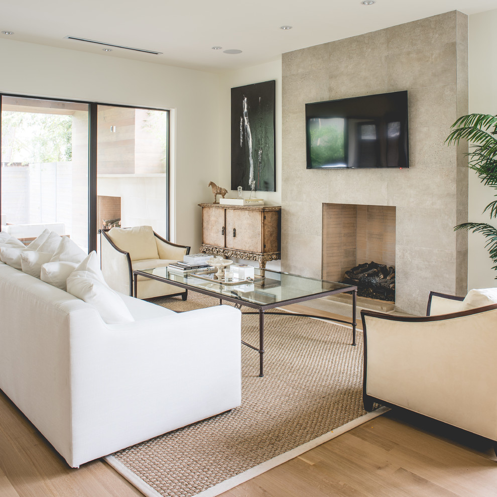 Mittelgroßes, Offenes Modernes Wohnzimmer mit beiger Wandfarbe, hellem Holzboden, Kamin, Kaminumrandung aus Stein und TV-Wand in Dallas