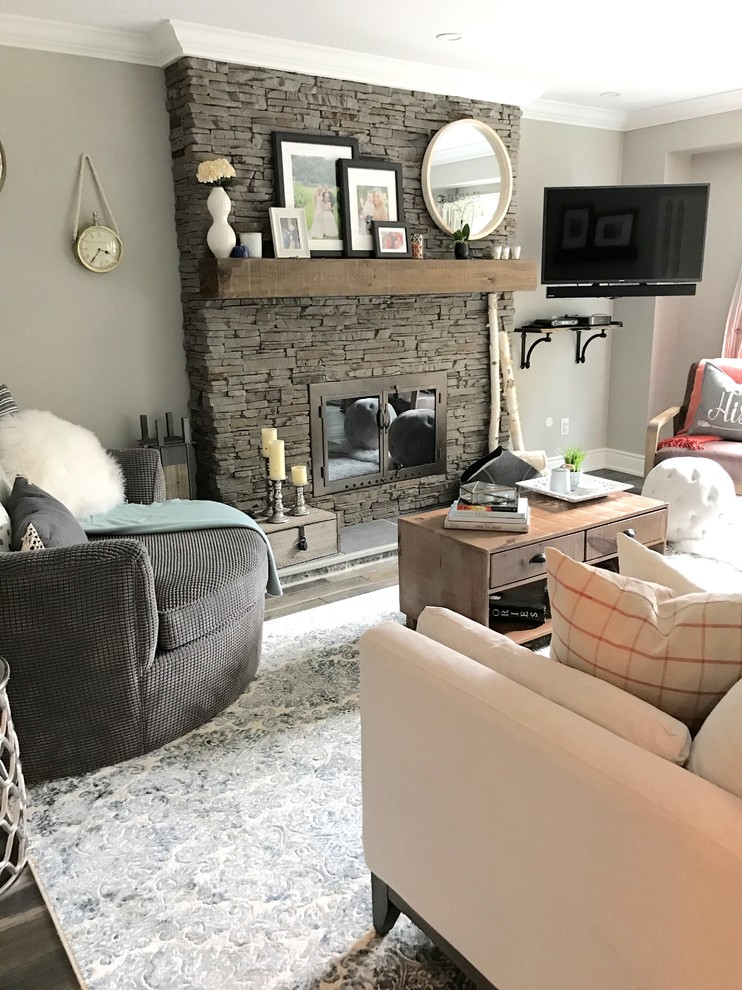 Mittelgroßes, Abgetrenntes Klassisches Wohnzimmer mit grauer Wandfarbe, dunklem Holzboden, Kamin, Kaminumrandung aus Stein, Eck-TV und braunem Boden in Toronto