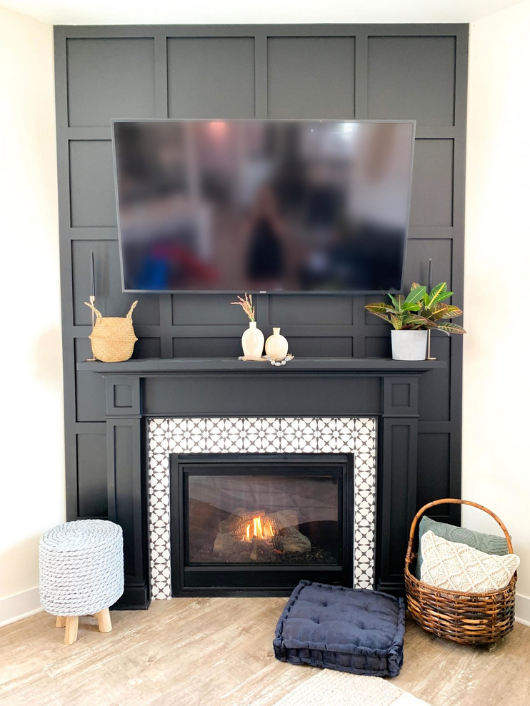 Foto på ett funkis allrum med öppen planlösning, med svarta väggar, laminatgolv, en öppen hörnspis, en spiselkrans i trä och en väggmonterad TV