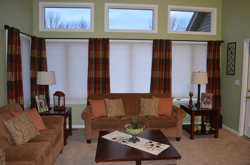 На фото: открытая гостиная комната в классическом стиле с зелеными стенами, ковровым покрытием, стандартным камином, фасадом камина из кирпича и отдельно стоящим телевизором