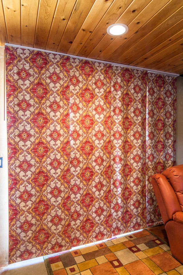 На фото: открытая гостиная комната среднего размера в стиле фьюжн с музыкальной комнатой, бежевыми стенами, бетонным полом, печью-буржуйкой, фасадом камина из бетона и красным полом без телевизора