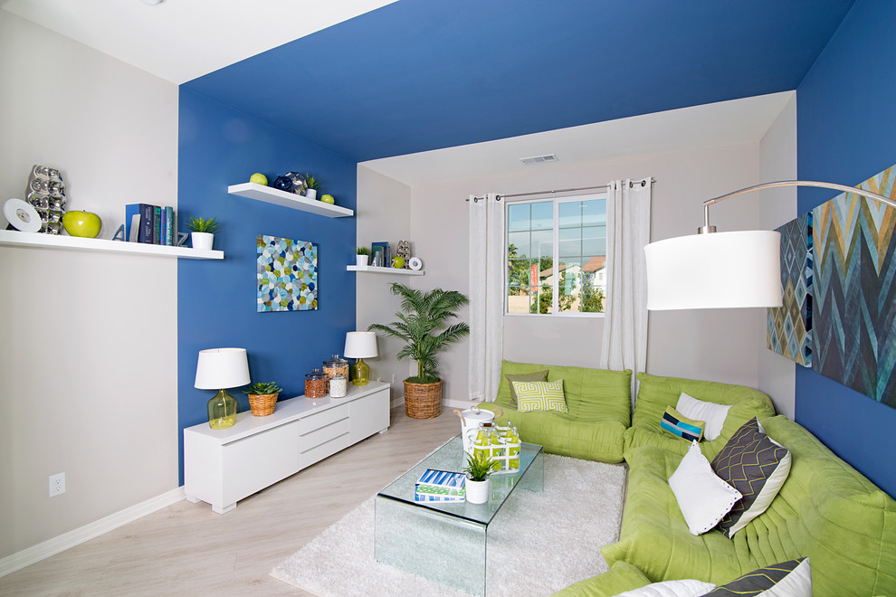 Foto de sala de estar tipo loft minimalista de tamaño medio sin televisor con paredes azules y suelo de madera clara
